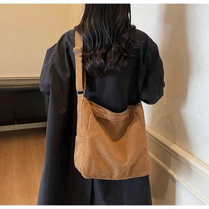 Detail of adjustable strap and brown suede texture on a vintage crossbody tote bag