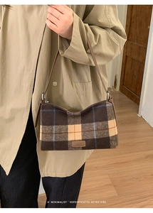 Détail du sac bandoulière rétro à carreaux avec sangle en cuir porté par un mannequin