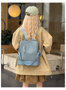 Detail of light blue backpack with woven texture and vertical zipper in street setting