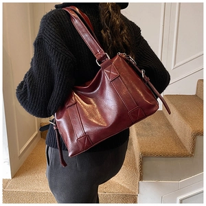 Close-up of vintage burgundy tote bag showing pebbled leather texture and silver hardware