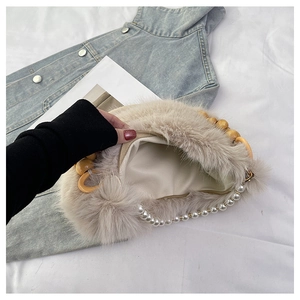 Détail du sac à main en fausse fourrure avec poignée en perles et ornements perlés