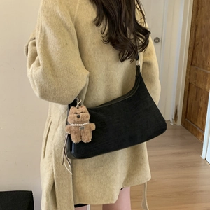 Minimalist black suede hobo bag with a cute brown plush bear charm and pearl detail