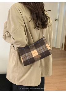 Detail of wool plaid tote bag on a khaki trench coat featuring a retro minimalist style