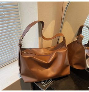 Detail of vintage brown leather tote bag with adjustable strap in a lifestyle setting