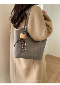 Détail du grand cabas en cuir taupe grainé avec un porte-clé peluche mignon