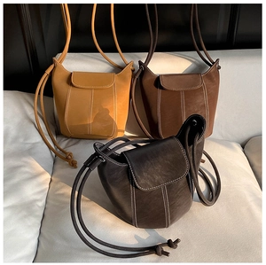 Detailed view of vintage bucket bags with contrast white stitching in yellow and brown