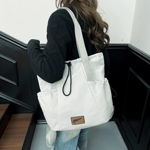 Minimalist off-white large capacity tote bag with drawstring and brown leather brand label