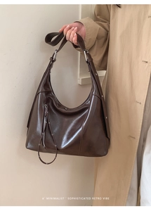 Detail of dark brown retro crossbody bag with decorative zipper and adjustable strap