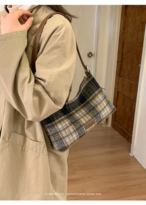 Detail of tweed checkered shoulder bag with leather strap and fashion label detail