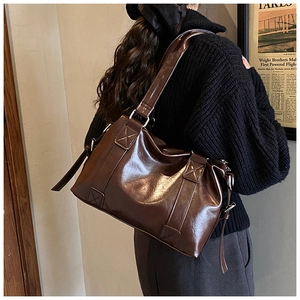 Detail of vintage dark brown oil wax leather tote with wide shoulder straps and silver hardware
