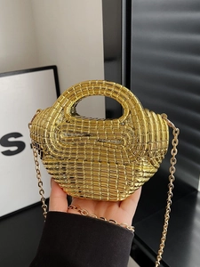 Borsa a mano intrecciata dorata con trama a griglia e tracolla a catena in mano