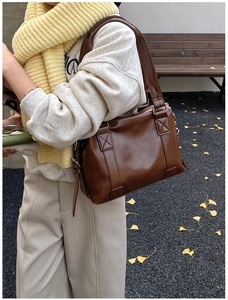 Detailed view of dark brown PU leather Boston bag with vintage cross-stitch handles