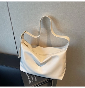 Detail of minimalist beige PU leather tote bag showing soft texture and metal buckle