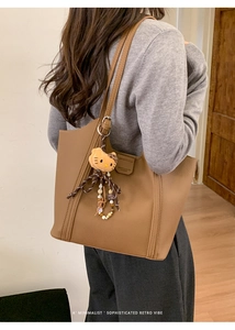 Détail du sac cabas en similicuir marron avec texture grainée et pendentif en peluche