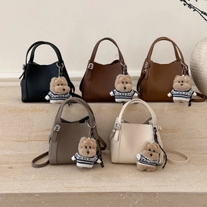 Detailed display of trapezoid leather bucket bags in five colors with dog charms