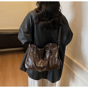 Détail de ce sac fourre-tout marron foncé avec texture cuir ciré vintage et rivets métal