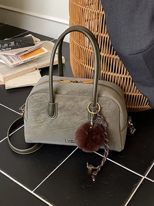 Vintage olive green Boston bag with texture, twin handles, and plush charm accessory