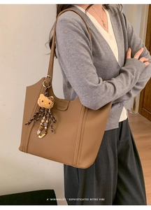 Détail d'un grand cabas en cuir marron foncé avec charm en peluche et coutures