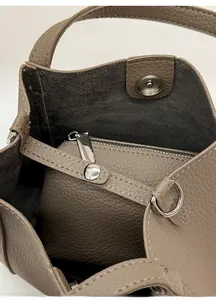 Close-up of khaki bucket bag interior with removable zipper pouch and magnetic clasp