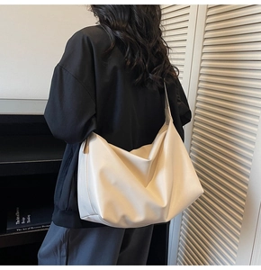 Vista posteriore di una modella con borsa a mezzaluna beige capiente in morbida pelle