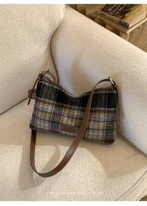 Détail du sac à bandoulière en laine à carreaux avec sangle en cuir et écusson
