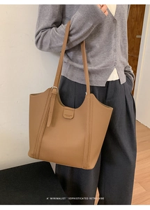 Gros plan d'un sac cabas minimaliste en cuir marron avec de longues bandoulières