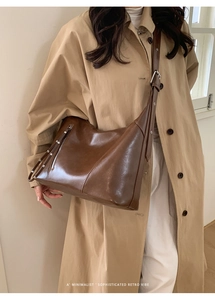 Detail of retro brown leather shoulder bag with tassels and adjustable strap on a model