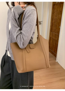 Détail du sac cabas en cuir marron à texture litchi avec sangles à coutures verticales
