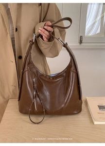 Detail of dark brown retro hobo bag with silver ring zipper and metallic buckle
