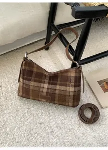Détail du sac à bandoulière vintage à carreaux avec fermeture éclair et sangle en cuir