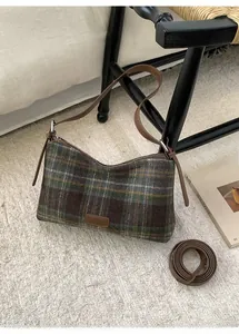 Détail du sac sous le bras en tweed à carreaux avec écusson en cuir et bandoulière