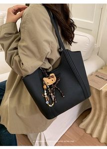 Détail du sac cabas noir en cuir grainé avec un pendentif peluche chaton mignon