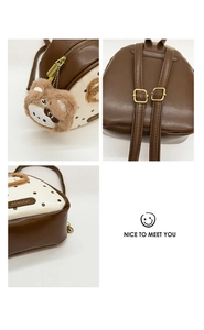 Close-up of brown and cream polka dot backpack with plush bear charm and gold hardware