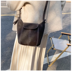 Detail of vintage bucket bag featuring contrast white stitching and knot shoulder strap
