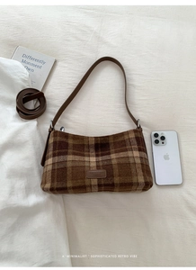 Détail d'un sac sous le bras vintage à carreaux marron avec texture en laine et logo