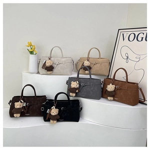 Detailed display of multi-color minimalist handbags with teddy bear charms and matte finish
