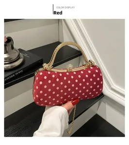 Close-up of red polka dot evening bag featuring gold metal frame and crystal clasp