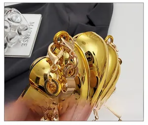 Detail view of the golden shell evening bag with metallic finish and sturdy chain connector