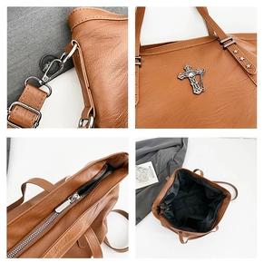 Detail view of brown tote bag hardware, star strap, metal cross and spacious interior