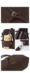 Close-up of suede shoulder bag details with silver hardware and a cute bear keychain