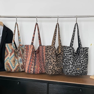 Detail view of large tote bags in geometric, striped, and leopard patterns on display