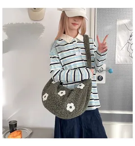Vue détaillée du sac bandoulière peluche gris foncé avec motif de fleur blanche
