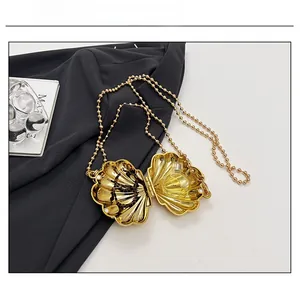 Macro view of golden shell chain bag interior showing space for perfume and small accessories