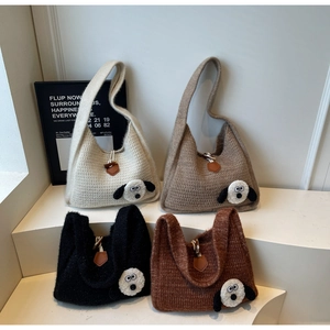 Detail view of four chunky knit hobo bags with 3D cartoon dog patches in various colors