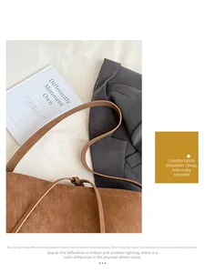 Overhead view of a brown faux leather tote bag with soft texture on a white cloth