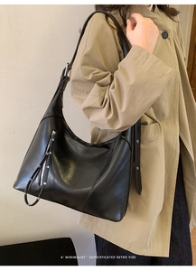 Detail of black semi-circle Hobo bag with silver buckle and long zipper puller strap