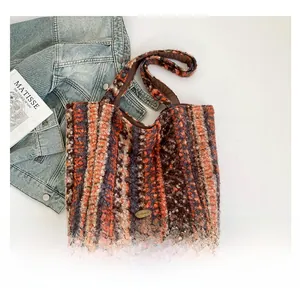 Detail showing colorful striped plush tote bag fabric with metallic logo on a denim jacket