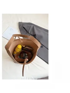 Top view of brown bucket bag interior showing large capacity for phone, umbrella and makeup
