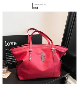 Detail view of red tote bag with retro metal cross pendant and punk chain accents