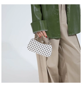 Detail of vintage polka dot box bag with gold metal handle and rhinestone buckle